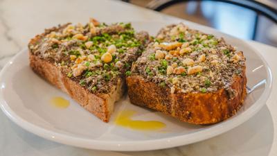 Dozen Bakery's Daily Tartine, loaded with mushrooms, on a white plate
