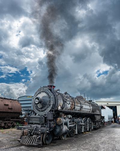 An old fashioned steam locomotive in a railyard