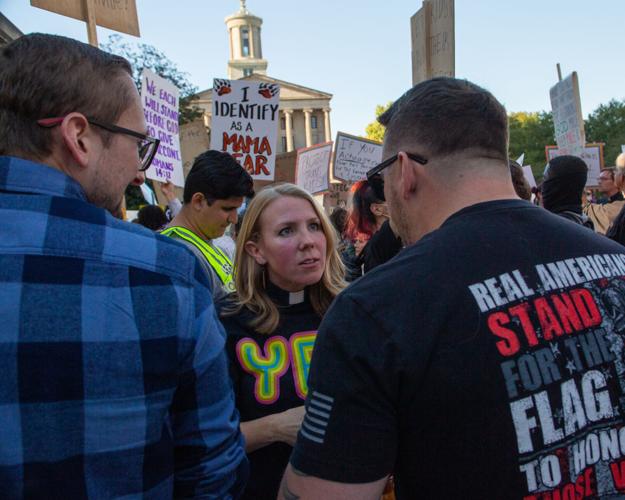 Chaplain speaks to crowd members at a rally against transgender health care, Oct. 21, 2022