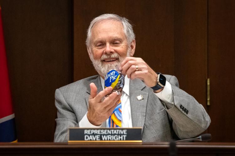 Rep. Dave Wright gleefully shows off a chocolate Moon Pie during a House Cities and Counties Subcommittee meeting, March 11, 2026