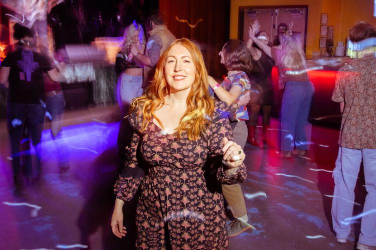 A woman stands in the middle of a dance floor