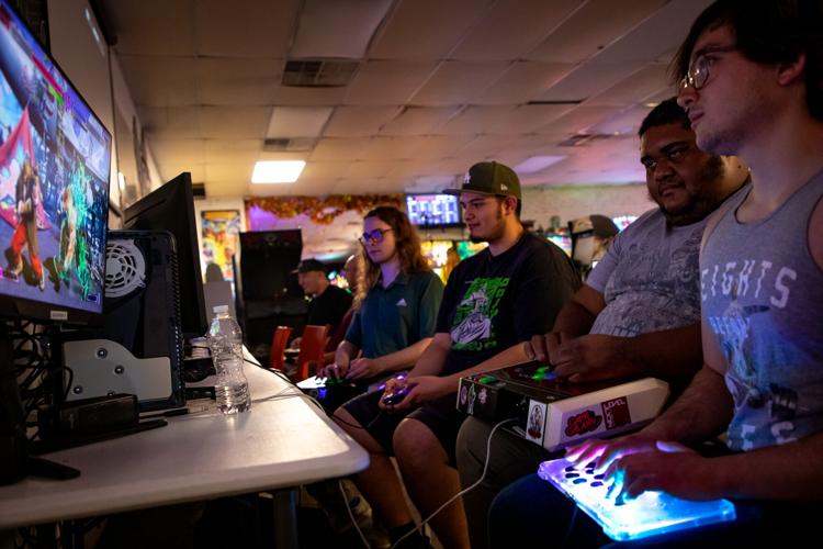 A row of players compete in different matches of Street Fighter at Game Galaxy