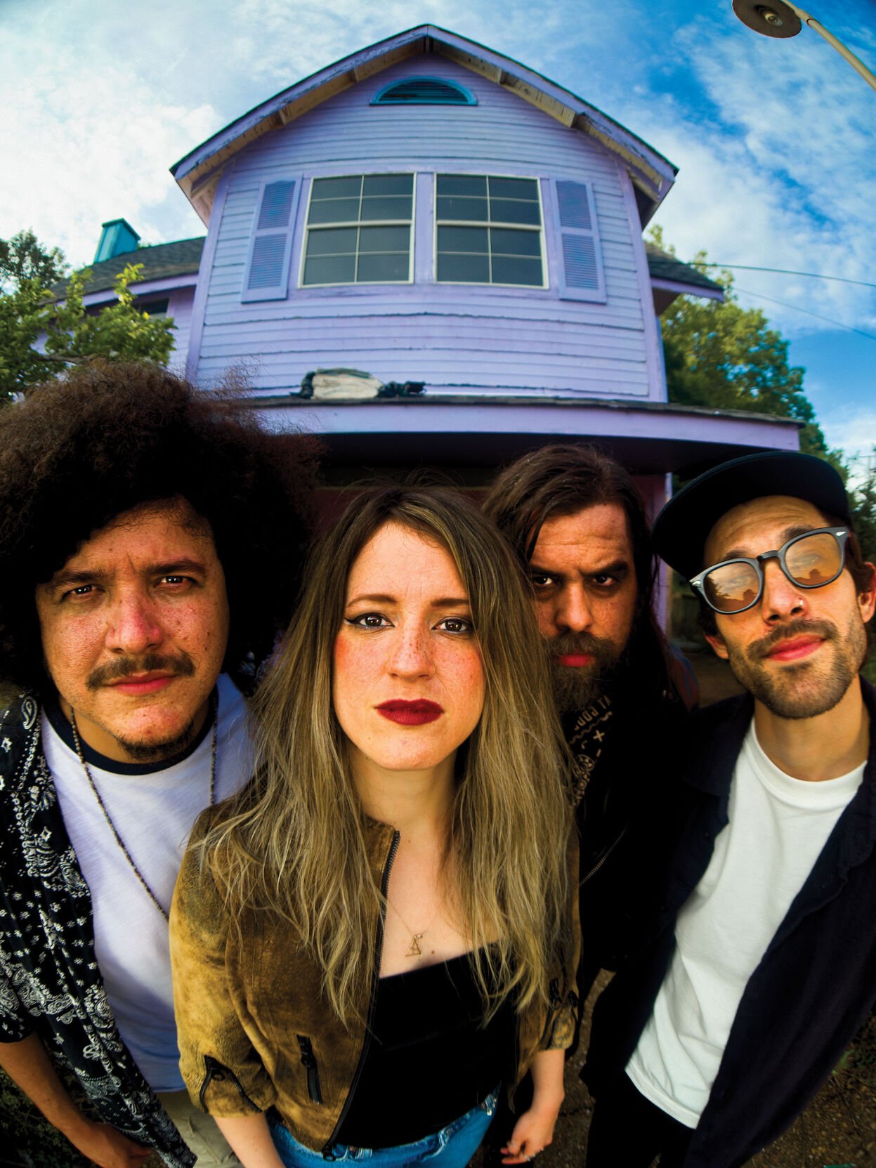 Sweet Lizzy Project press photo 2025 band poses in front of their home