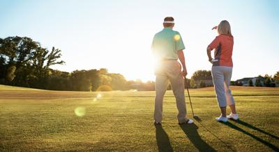 Shot of a retired couple standing on a golf green