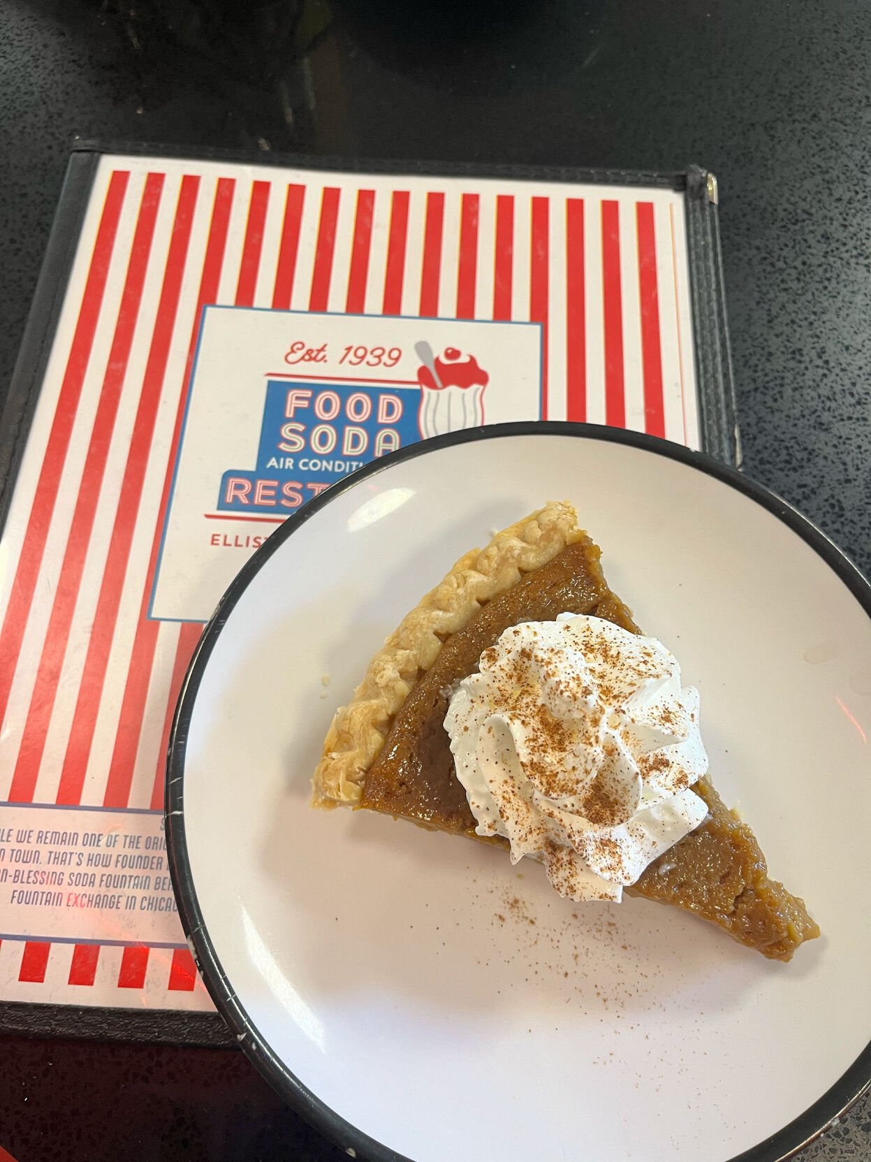 A slice of pumpkin pie with whip cream