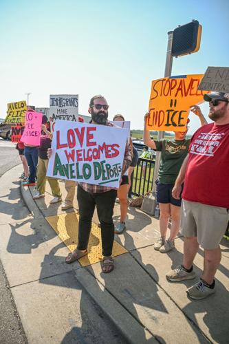 Protester holds sign reading "Love welcomes, Avelo deports"