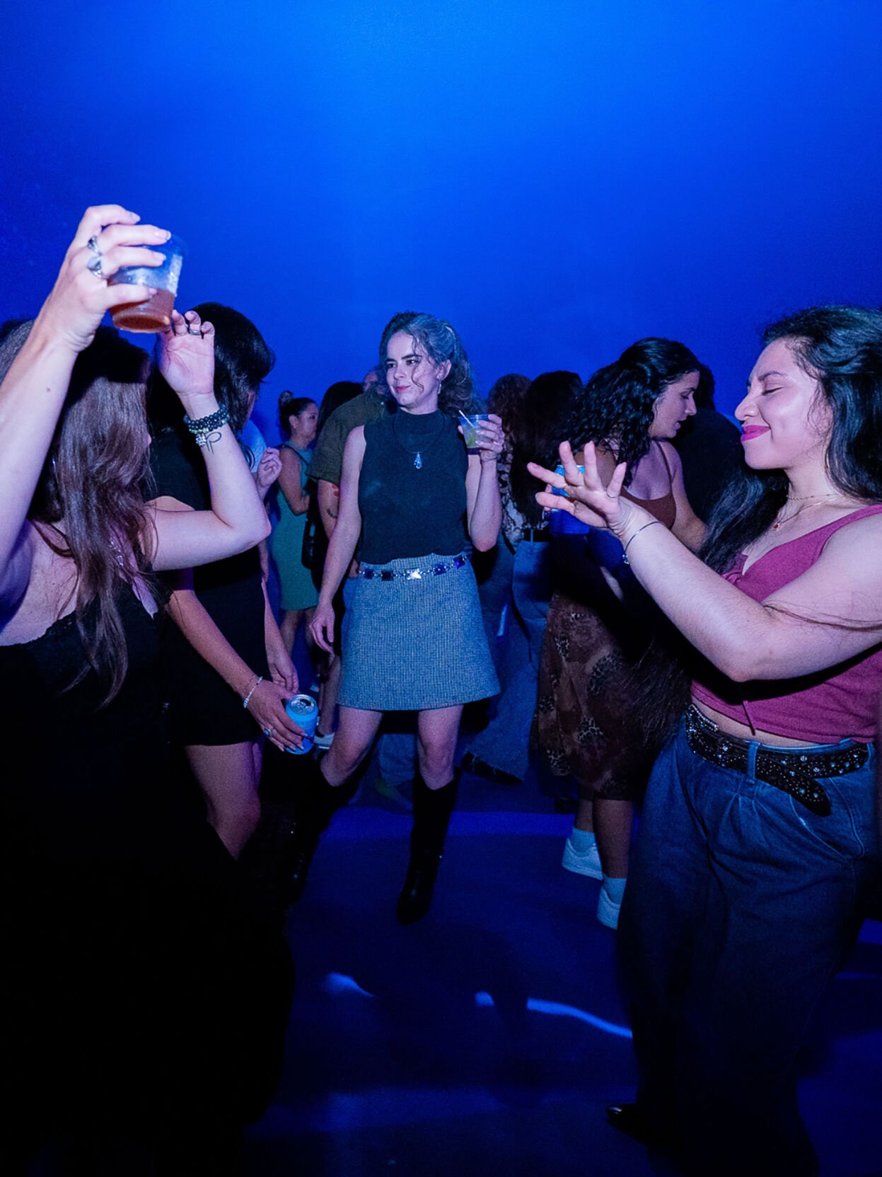 Esencial Latin dance party promo photo a crowd dances against a blue background