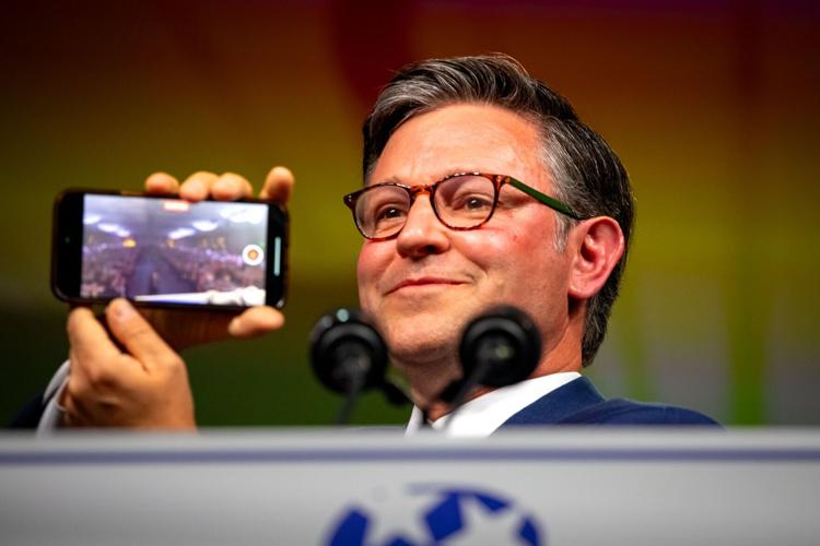 Mike Johnson holding up his phone