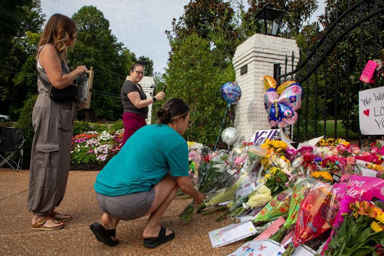 Dolly Parton fans mourn her passing, adding flowers and other mementos to a growing memorial at the gates of her Brentwood home the day after her death, Aug. 26, 2026