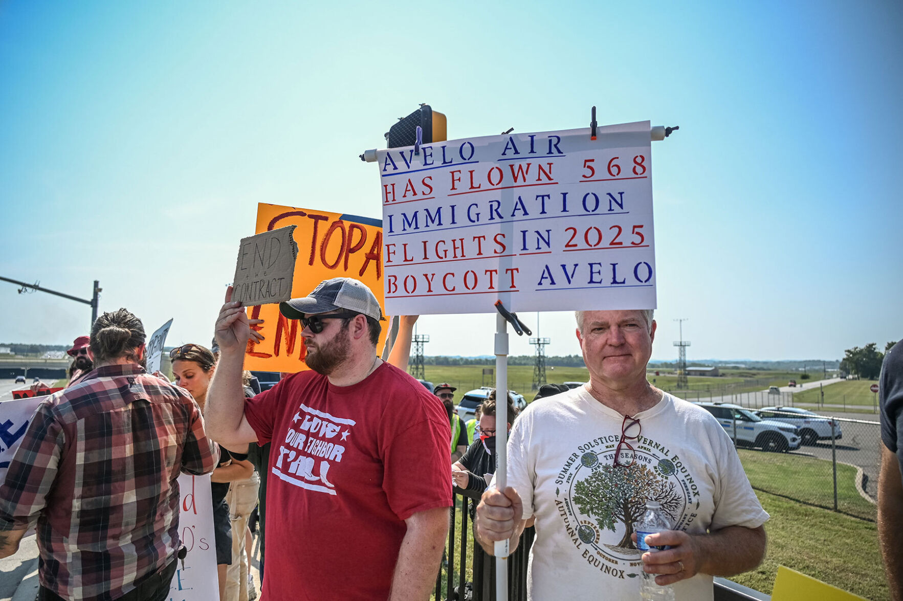 Protester holding sign reading "Avelo Air has flown 568 immigration flights in 2025, boycott Avelo"