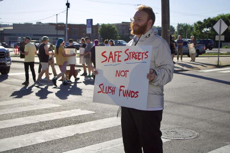 Protesters holding signs stand outside and advocate for safe streets in downtown Nashville, May 11, 2026