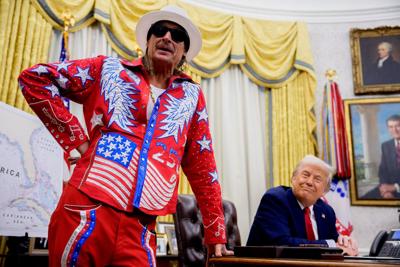 President Donald Trump listens as Kid Rock speaks during an executive order signing event in the Oval Office, March 31, 2025