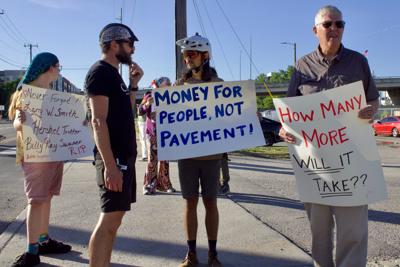 A group of protesters, some wearing bike helmets, stand outside and advocate for safe streets in downtown Nashville, May 11, 2026