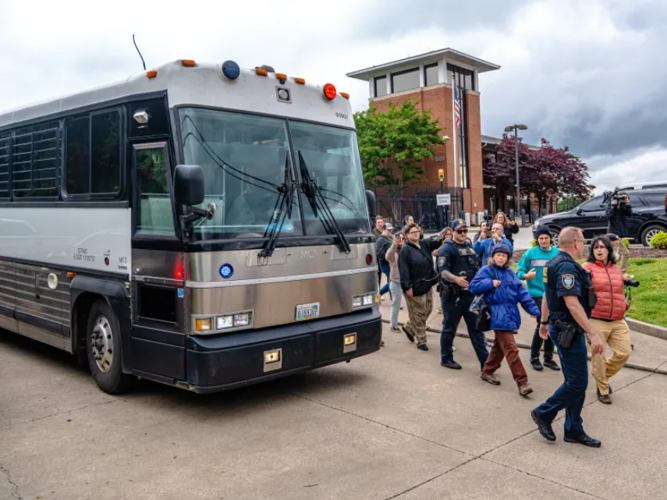 Activists protest as a detention bus leaves the ICE field office, May 4, 2025