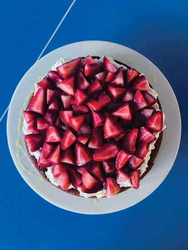 A bird’s eye view of a chocolate cake with cream and strawberries