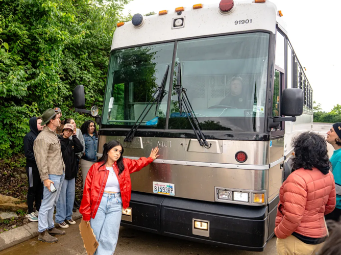 Gisselle Huerta stands in the path of a detention bus as it exits the ICE field office, May 4, 2025