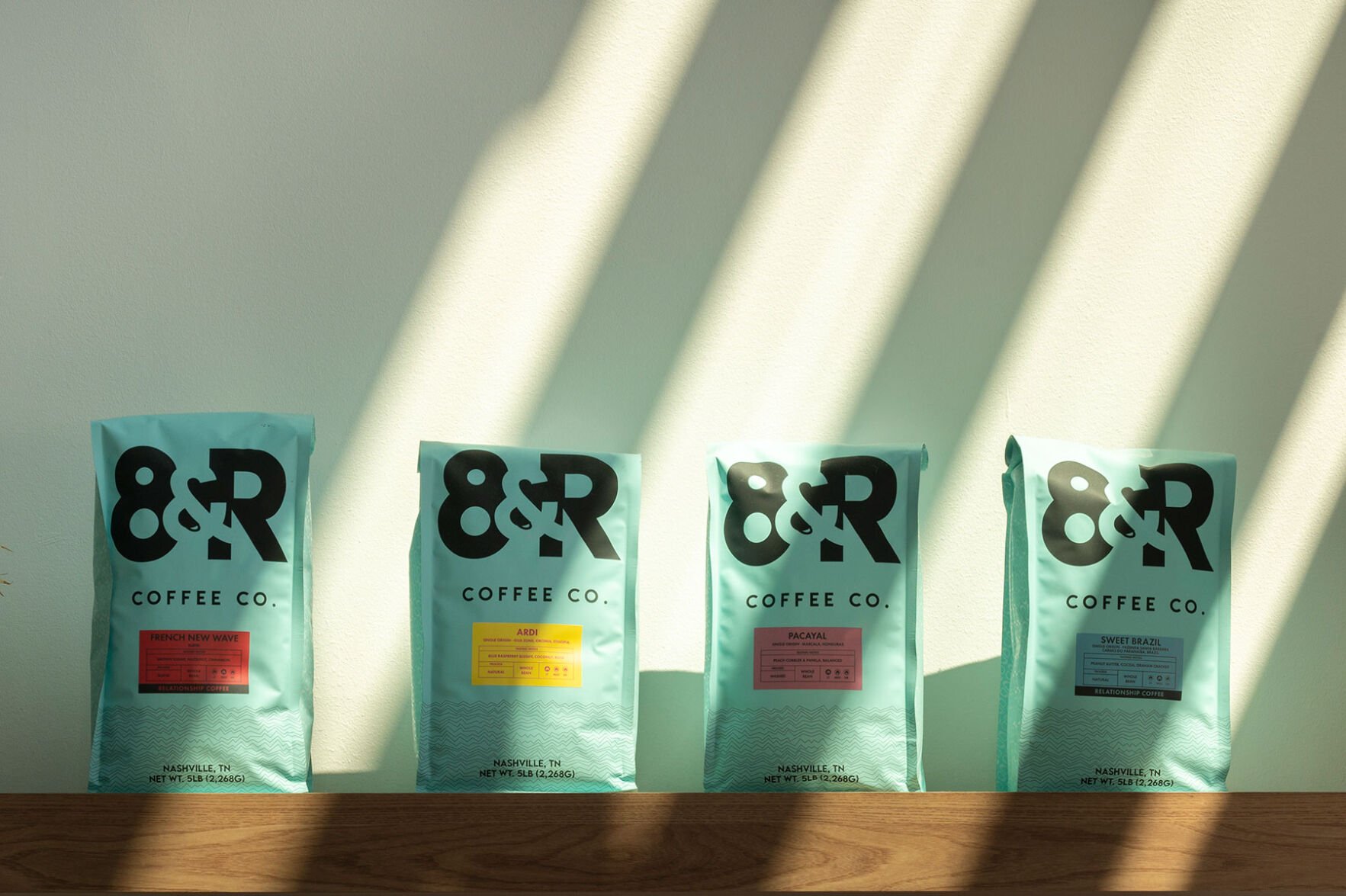 Four bags of 8th & Roast Coffee lined up in a row
