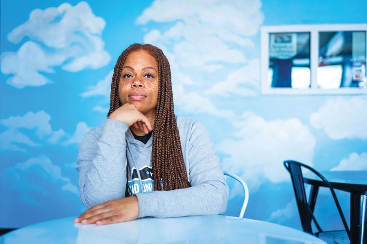 Rasheedat Fetuga sitting in front of a blue cloud background