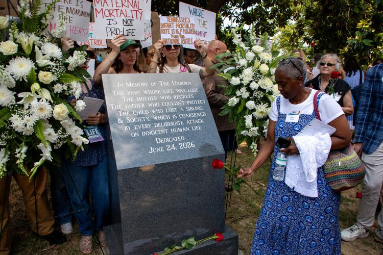 Anti-abortion advocate Regina Paulsen places a rose at the base of an anti-abortion memorial, June 24, 2026
