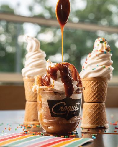 Two waffle cones flank a sundae in a plastic cup from Croquet Cafe