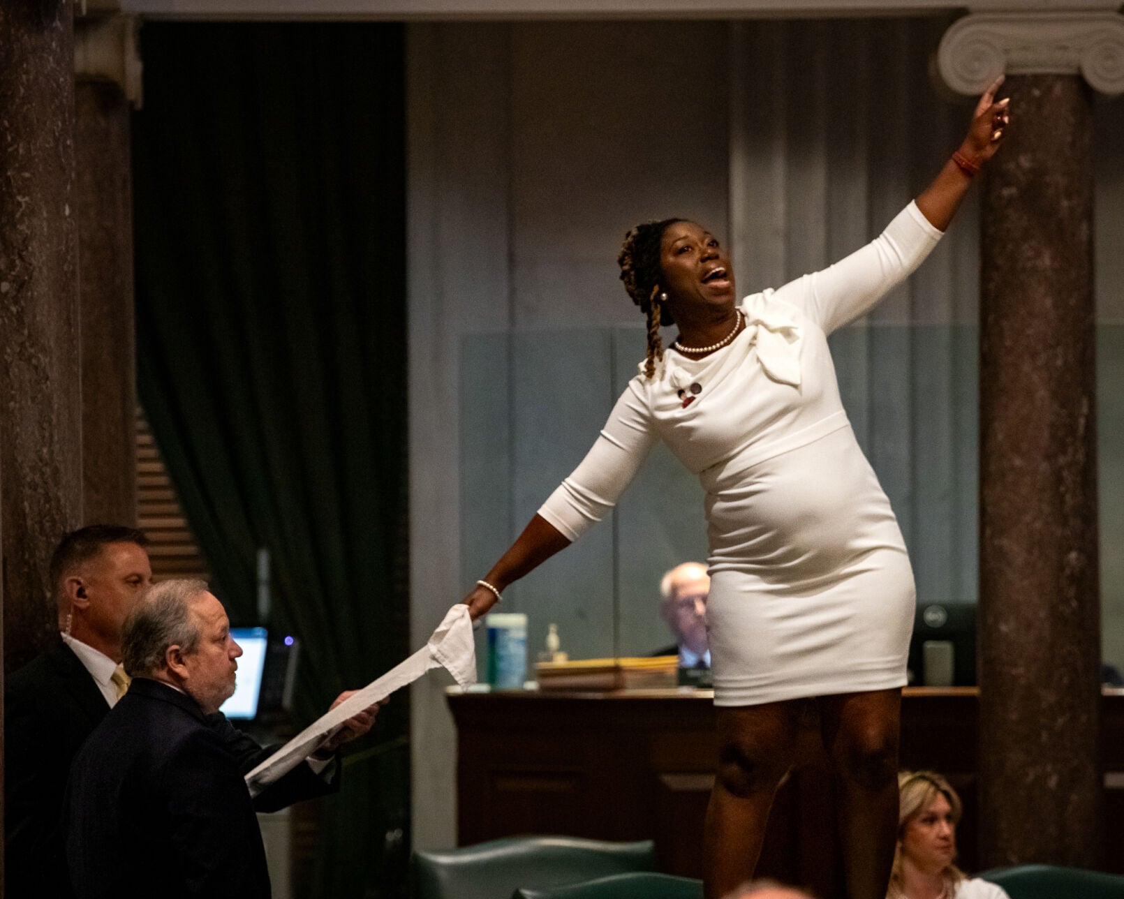 Sen. Charlane Oliver stands on her desk and displays a banner in protest of congressional redistricting, May 7, 2026