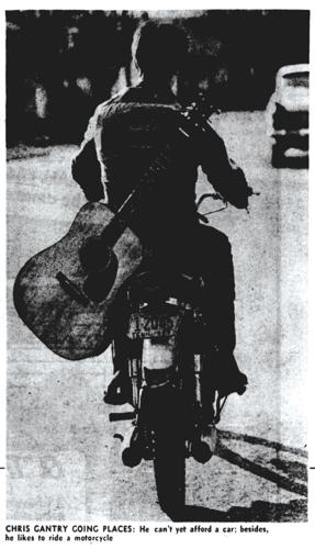 Black-and-white photo of Chris Gantry riding away from the camera on a motorcycle with an acoustic guitar on his back. Originally published in 'The Tennessean' on March 6, 1966.