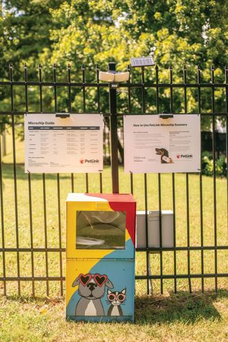 The Nashville Humane Association’s 24-Hour Microchip Scanner is a colorful box with an illustration of a dog and cat, both wearing sunglasses, resting against a fence with instructions posted over it.