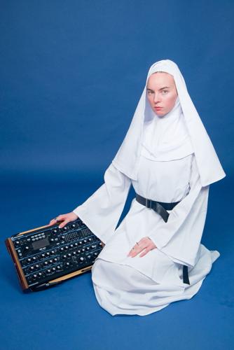 Musician Eve Maret, dressed in a nun’s habit, poses with a piece of modular synthesizer equipment