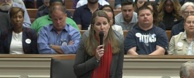Angie Henderson speaks in front of a gallery packed with Titans fans, April 18