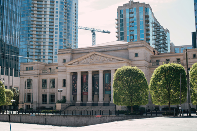 Color photograph of the front face of the Schermerhorn Symphony Center, taken in daylight with office buildings and construction cranes in the background.