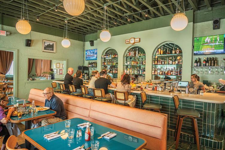 The inside of a busy restaurant with diners at booths and at the bar