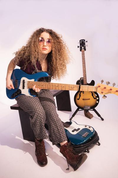 Tal Wilkenfeld press photo artist poses in sunglasses with two bass guitars