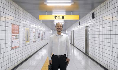 A man smiles in a hallway at a subway station in 'Exit 8'