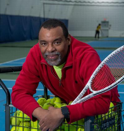 Rodney Williams holds a racket on a tennis court