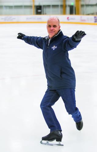 A man skating on the ice at an indoor rink