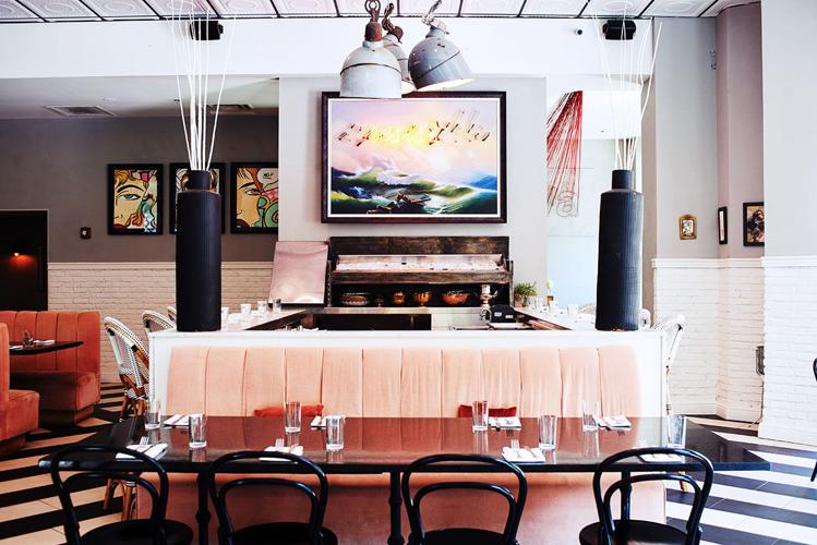 A pink booth with a small bar behind it, in a colorful restaurant space