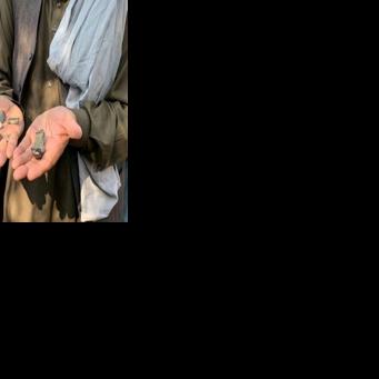 An Afghan man shows mortar shell remains in the Ghani Khel district of Nangarhar province on March 1, 2026 amid ongoing cross-border fighting between Afghanistan and Pakistan.