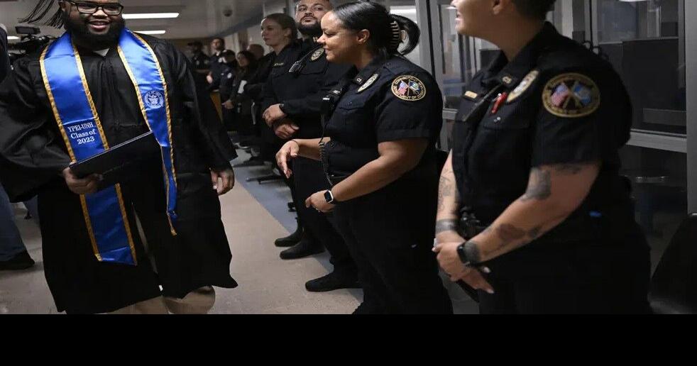 Graduate Alpha Jalloh walks with his diploma past correction officers