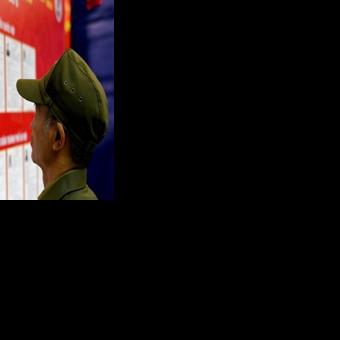 A man views the list of candidates for the upcoming National Assembly and local People's Council elections at a polling station in Hanoi