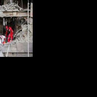 First responders search an office building that housed the offices of the Doha-headquartered news network Al Araby TV following a missile strike in Tehran