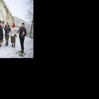 Local women in traditional dress sing carols outside a 'basca' hobbit house in Rogojeni, Moldova