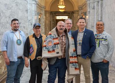 State Rep. Joel Kretz, R-7th (center) receives a ceremonial blanket from representatives of the Colville Confederated Tribes, 3-26-2024