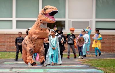 trick treat gazette hours school walks wears katelyn inflatable dinosaur elementary teacher costume grade building around she