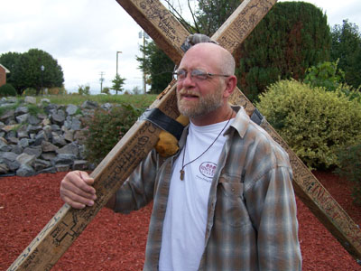 Carrying 50-pound cross, man on journey of hope, salvation