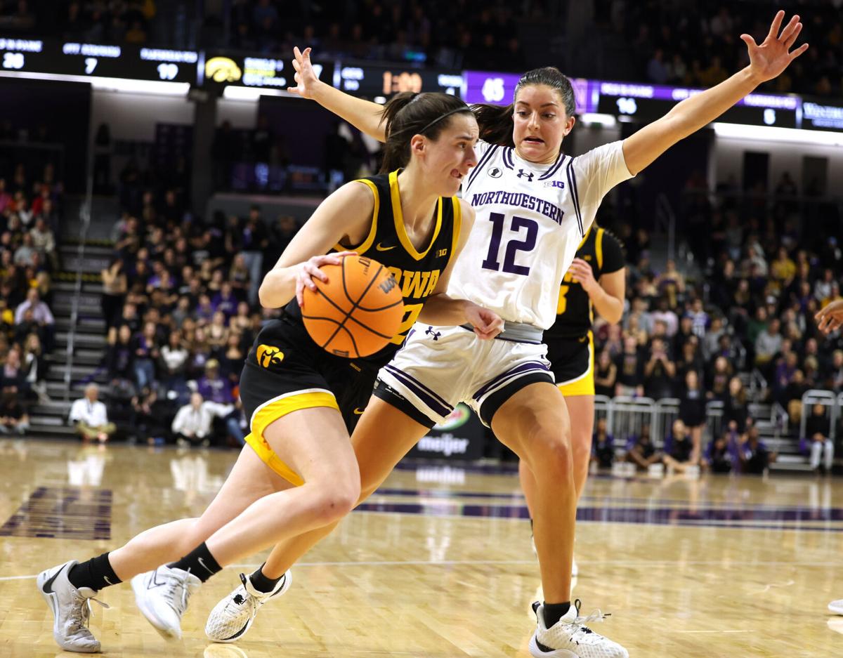 Iowa Hawkeyes guard Caitlin Clark (22) drives to the basket while being guarded by Northwestern Wildcats guard Casey Harter (12) in the second half at Welsh-Ryan Arena on Wednesday, Jan. 31, 2024, in Evanston.  Iowa defeated Northwestern 110-74 with Cla...