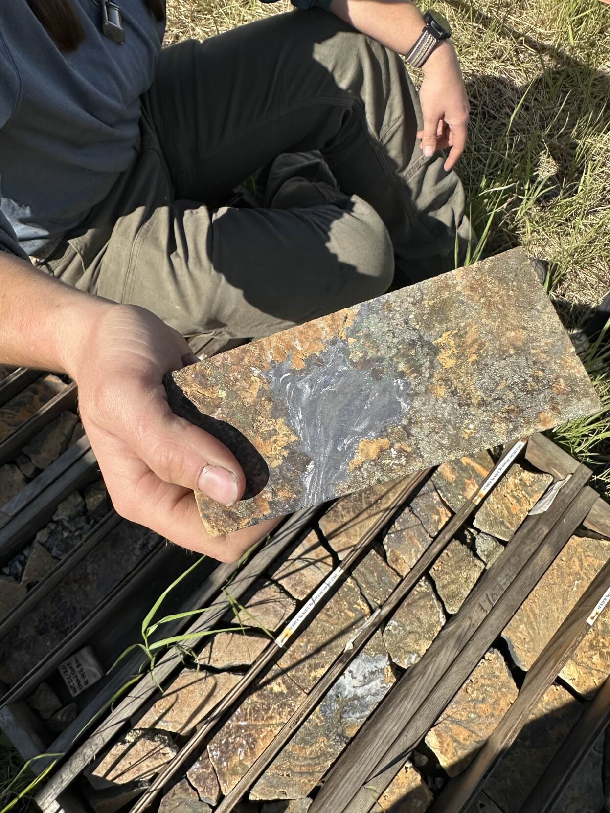 Close up of critical minerals in a rock sample held by an unknown person