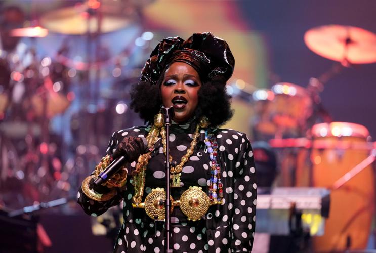 A vivid scene from Lauryn Hill's unforgettable Essence Festival performance, adorned in striking attire.