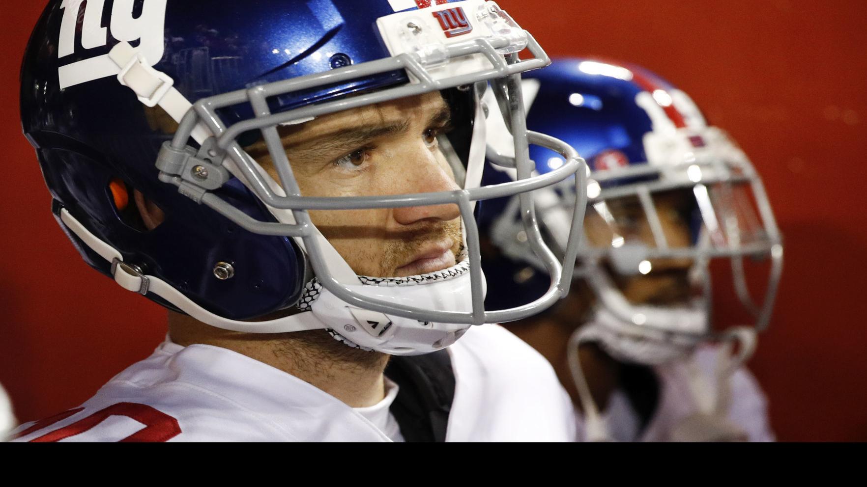 New York Giants quarterback Eli Manning gets face masked in the