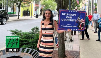 Tammy Bronsburg holding a sign saying Help Save Our Country outside Executive Plaza Williamsport.jpg