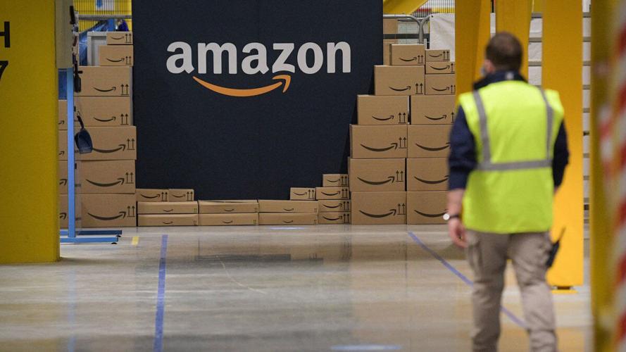 an-amazon-worker-approaches-a-stack-of-boxes